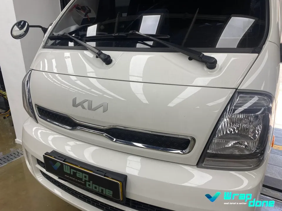 Kia Bongo 3のカーラッピング事例：フロント部分のポイント施工 施工写真 2-1